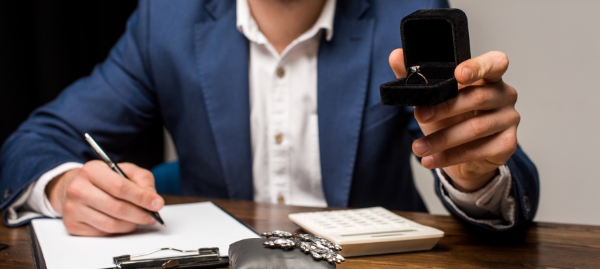 Man writing on clipboard for a jewelry appraisal
