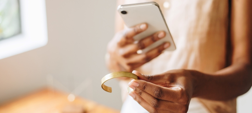 Person taking a picture of a bracelet with their phone