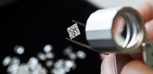 Inspecting a diamond in a tweezers 