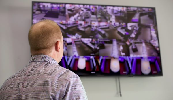 Man watching security footage of store