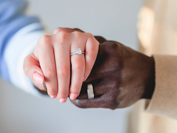 Hands holding wearing wedding rings