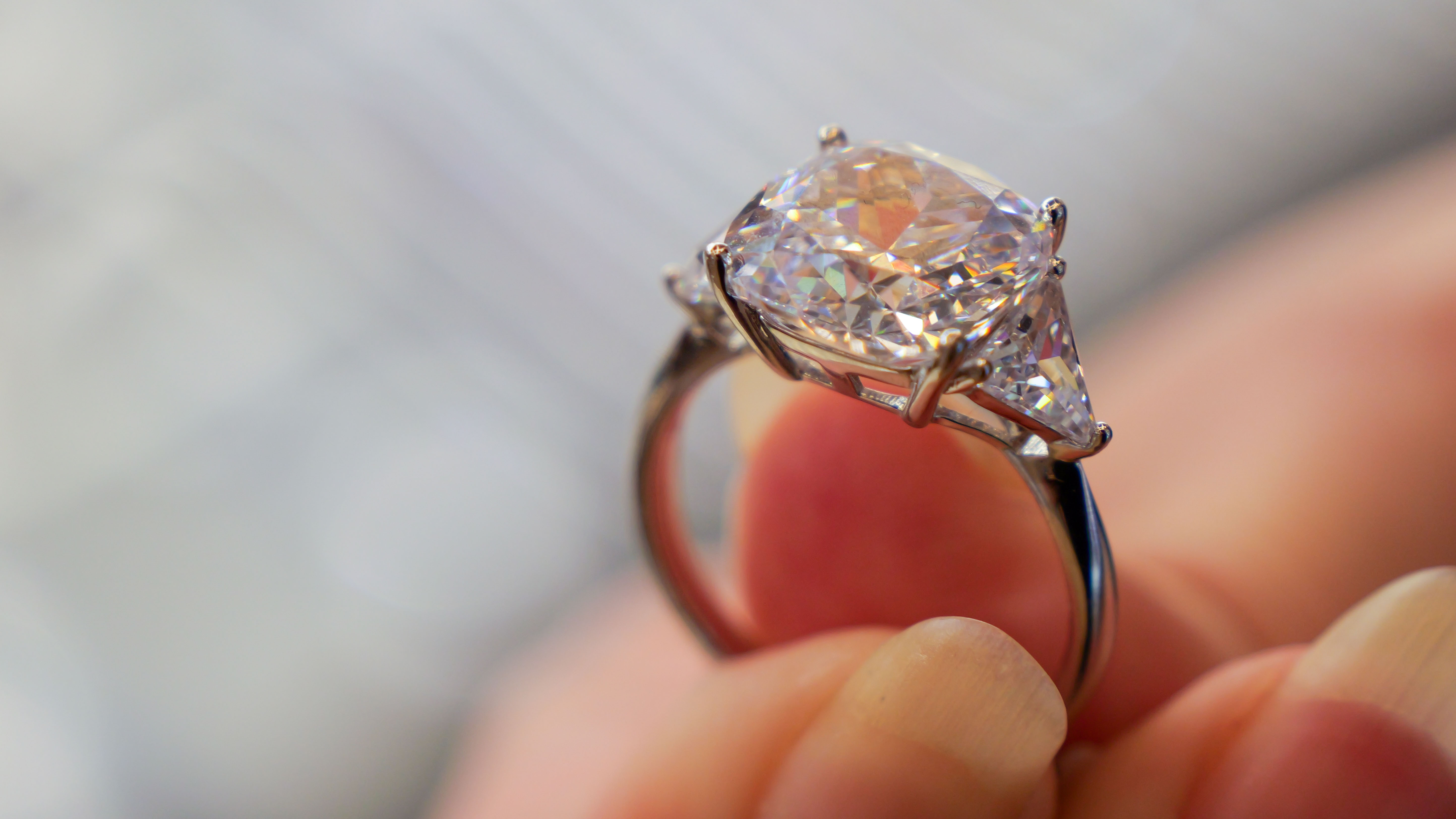 person holding diamond ring with large old mine cut diamond