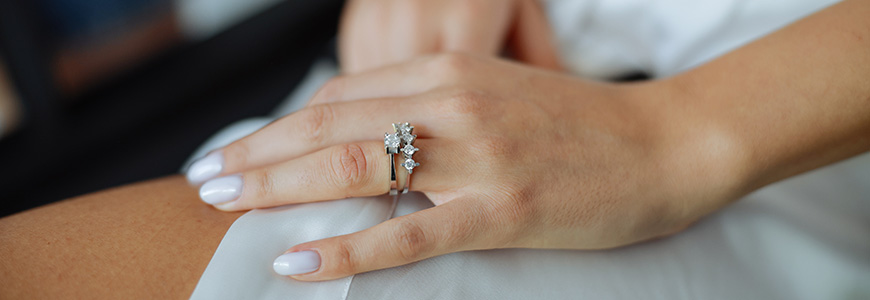 woman rests hand with large engagement ring on it on thigh
