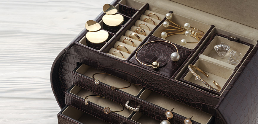 brown leather jewelry box holding a variety of jewelry