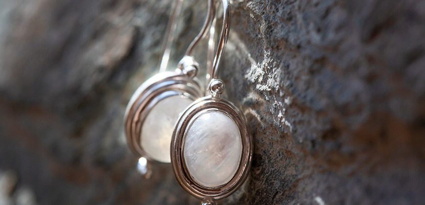 pair of oval moonstone earrings laying side by side 