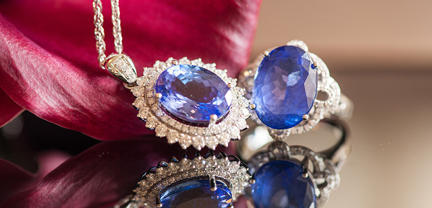sapphire ring and sapphire necklace on reflective table 