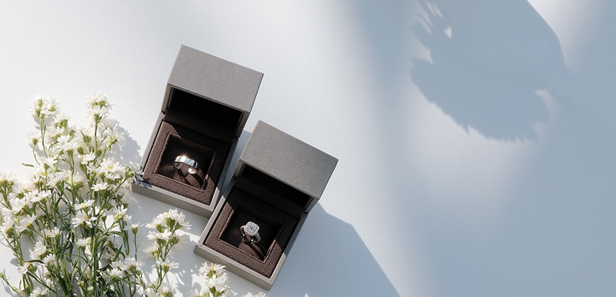 tungsten gents band in a box next to diamond wedding ring in a box