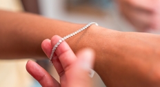 woman tries on dainty diamond bracelet on left hand
