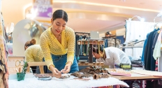 woman works jewelry table at craft fair