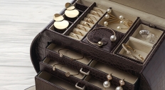 brown leather jewelry box holding a variety of jewelry