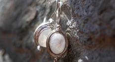 a pair of oval moonstone earrings laying side by side