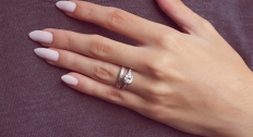 woman's hand with large diamond ring and silver wedding band