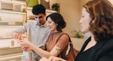 couple looks at diamond jewelry alongside jeweler